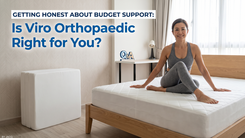 A lady sitting comfortably on a clean, firm Viro orthopaedic mattress on a wooden bed frame, with a folded Viro orthopedic foam mattress standing neatly in the corner of a bright, minimalist bedroom.